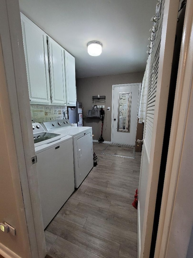washroom with cabinet space, washing machine and dryer, and light wood-type flooring