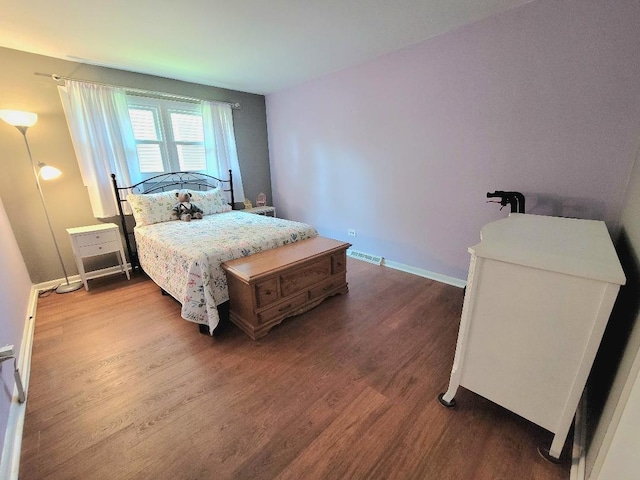bedroom featuring dark wood finished floors and baseboards