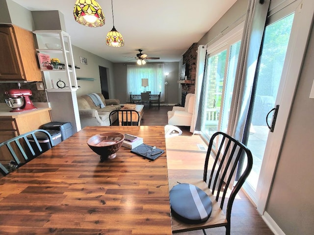 dining space with a ceiling fan and wood finished floors