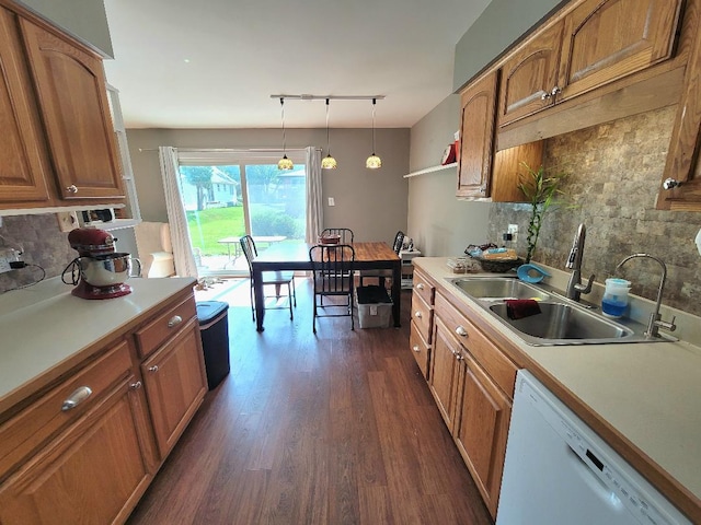 kitchen with a sink, white dishwasher, brown cabinetry, tasteful backsplash, and dark wood-style floors