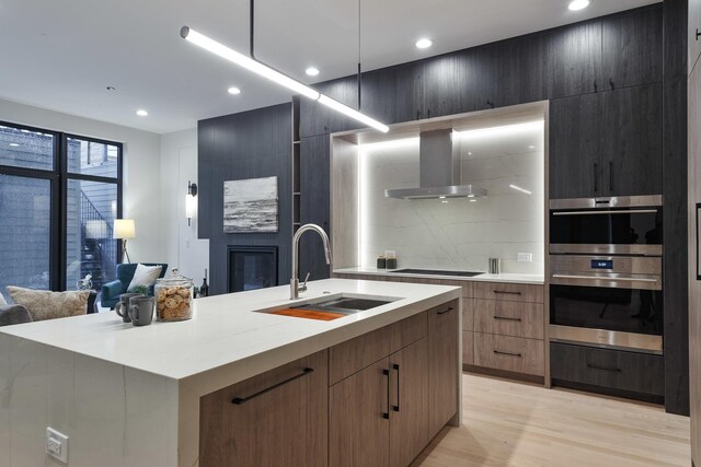 2049 W Race Ave, Chicago, IL 60612 - kitchen with wall chimney range hood, modern cabinets, a sink, an island with sink, and recessed lighting