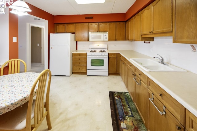 7021 W Touhy Ave Unit 305, Niles, IL 60714 - kitchen featuring white appliances, a sink, light floors, and brown cabinets