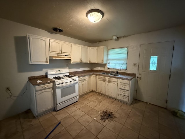 1869 Summit Ave, Kankakee, IL 60901 - kitchen featuring white range with gas cooktop, under cabinet range hood, dark countertops, white cabinets, and a textured ceiling