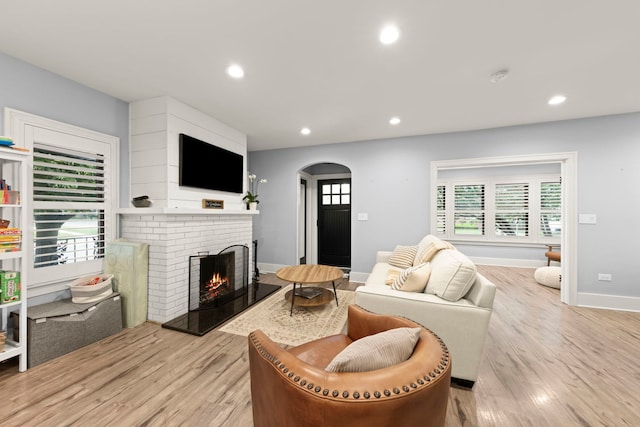 24202 W Commercial St, Plainfield, IL 60544 - living area with arched walkways, a brick fireplace, light wood finished floors, recessed lighting, and healthy amount of natural light