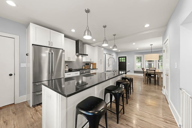 24202 W Commercial St, Plainfield, IL 60544 - kitchen with appliances with stainless steel finishes, wall chimney range hood, a sink, baseboards, and light wood-type flooring