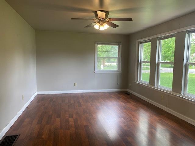 206 E Front St, Granville, IL 61326 - unfurnished room featuring dark wood-style flooring, a ceiling fan, and baseboards
