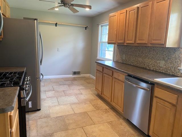 206 E Front St, Granville, IL 61326 - kitchen with appliances with stainless steel finishes, dark countertops, ceiling fan, backsplash, and baseboards