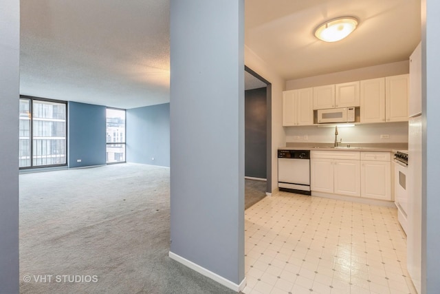 70 W Huron St Unit 1607, Chicago, IL 60654 - kitchen featuring white appliances, white cabinets, a sink, and baseboards