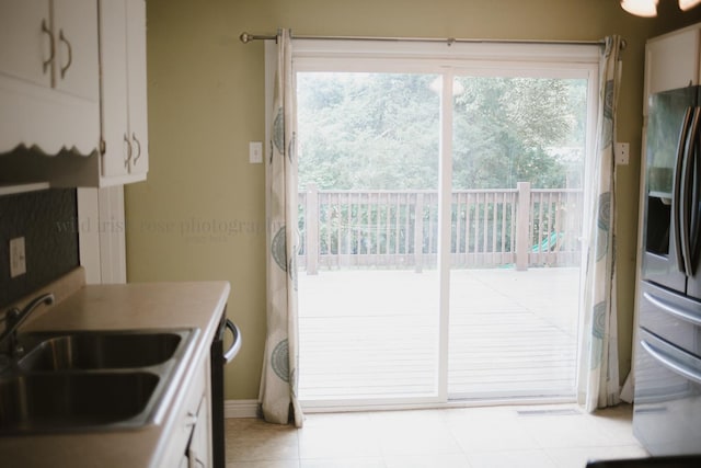 48 Norman St, Kankakee, IL 60901 - kitchen with a sink, stainless steel fridge with ice dispenser, light tile patterned floors, white cabinetry, and baseboards