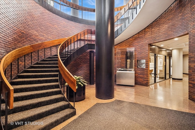155 N Harbor Dr Unit 610, Chicago, IL 60601 - staircase with a high ceiling, speckle patterned floor, and brick wall
