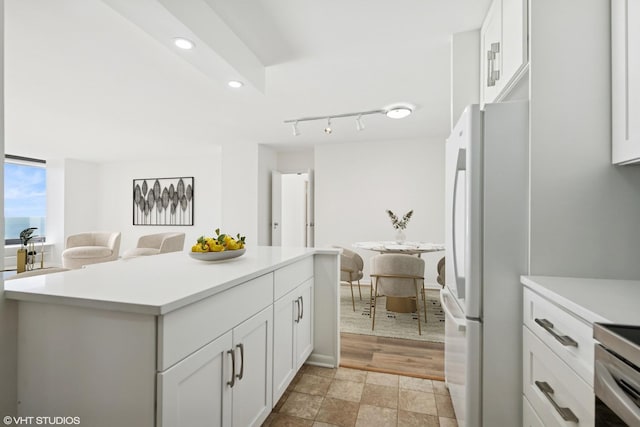 155 N Harbor Dr Unit 610, Chicago, IL 60601 - kitchen with freestanding refrigerator, light countertops, white cabinets, a kitchen island, and recessed lighting