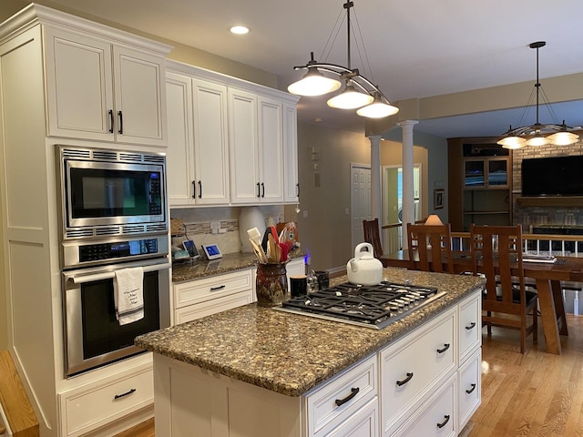 1312 Galloway Dr, Woodstock, IL 60098 - kitchen with appliances with stainless steel finishes, light wood-type flooring, ornate columns, dark stone counters, and recessed lighting