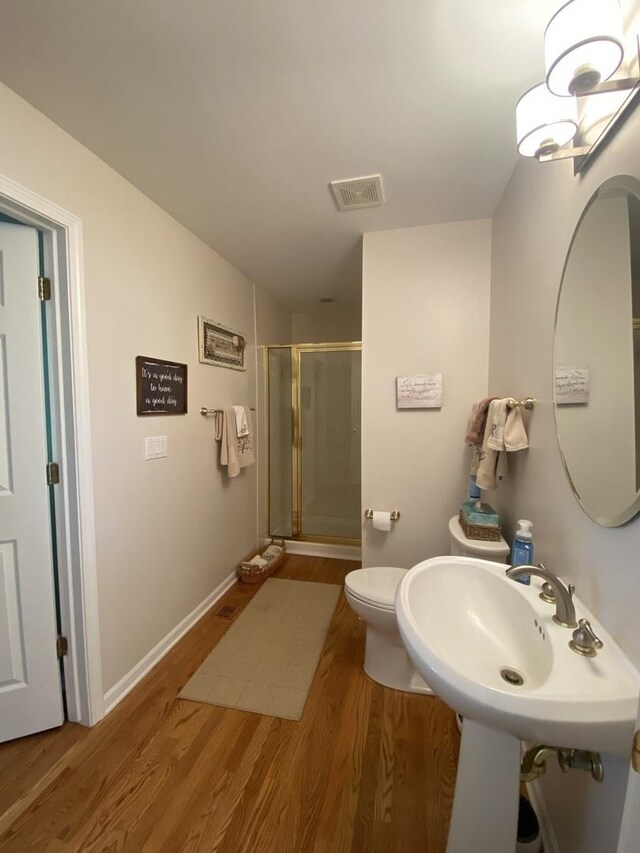 1312 Galloway Dr, Woodstock, IL 60098 - bathroom with wood finished floors, a stall shower, toilet, and baseboards