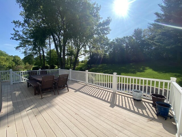1312 Galloway Dr, Woodstock, IL 60098 - deck with outdoor dining area, a yard, and view of scattered trees