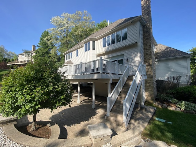 1312 Galloway Dr, Woodstock, IL 60098 - back of property featuring a wooden deck, a chimney, stairs, a patio area, and roof with shingles