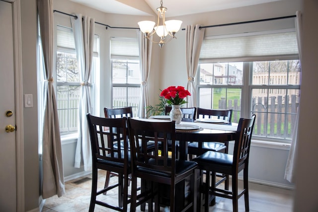 dining space with a chandelier and baseboards
