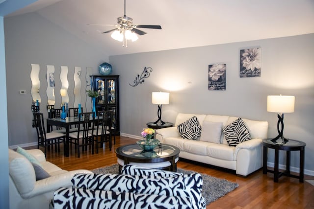 living area featuring ceiling fan, wood finished floors, lofted ceiling, and baseboards