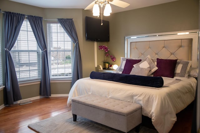 bedroom with baseboards, wood finished floors, and a ceiling fan