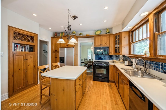 944 Fair Oaks Ave, Oak Park, IL 60302 - kitchen with black appliances, light wood-type flooring, a kitchen island, brown cabinets, and recessed lighting