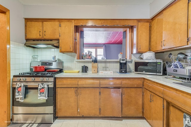 4536 W 79th Pl, Chicago, IL 60652 - kitchen with stainless steel appliances, under cabinet range hood, light countertops, and brown cabinetry