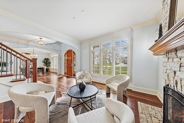 210 S Prospect St, Clarendon Hills, IL 60514 - living room featuring arched walkways, crown molding, dark wood-style flooring, stairs, and a fireplace