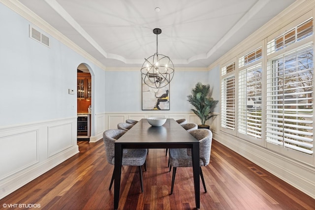 210 S Prospect St, Clarendon Hills, IL 60514 - dining space with a raised ceiling, a chandelier, dark wood-type flooring, arched walkways, and wainscoting