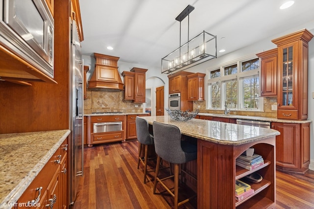 210 S Prospect St, Clarendon Hills, IL 60514 - kitchen featuring appliances with stainless steel finishes, brown cabinets, recessed lighting, a center island, and backsplash