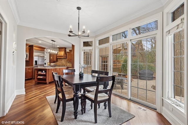 210 S Prospect St, Clarendon Hills, IL 60514 - dining area with arched walkways, a chandelier, wood-type flooring, ornamental molding, and baseboards