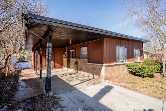 458 Tahoe St, Park Forest, IL 60466 - view of side of home featuring concrete driveway, brick siding, a carport, and board and batten siding