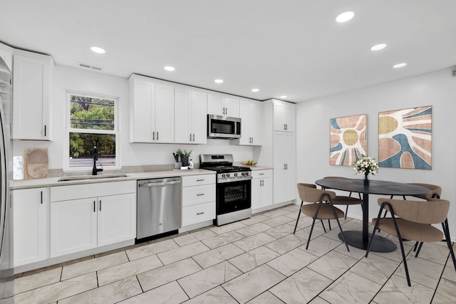 1815 N Bissell St Unit 3, Chicago, IL 60614 - kitchen featuring appliances with stainless steel finishes, a sink, light countertops, recessed lighting, and white cabinets