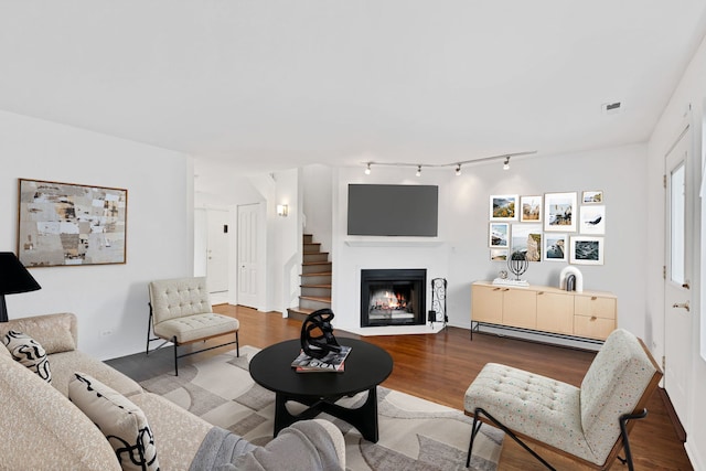 1815 N Bissell St Unit 3, Chicago, IL 60614 - living area featuring baseboard heating, wood finished floors, a lit fireplace, and rail lighting