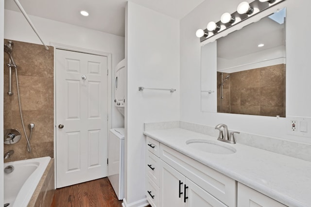 1815 N Bissell St Unit 3, Chicago, IL 60614 - bathroom featuring stacked washer / dryer, vanity, wood finished floors, and tiled shower / bath combo
