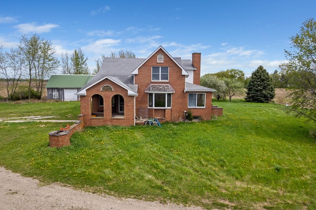 traditional-style house with a chimney, brick siding, and a front lawn