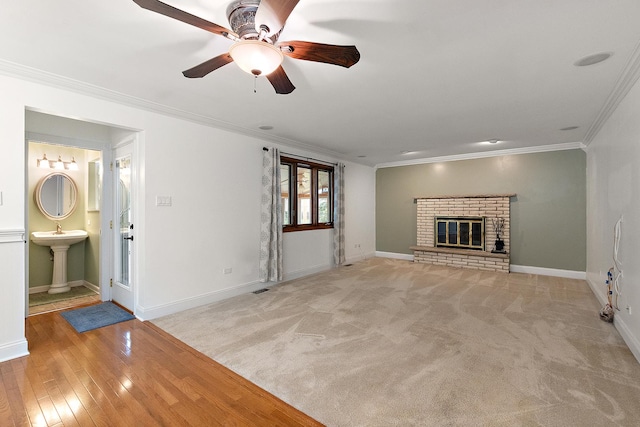 8144 Bunker Dr, Orland Park, IL 60462 - unfurnished living room featuring a ceiling fan, crown molding, a sink, baseboards, and a brick fireplace