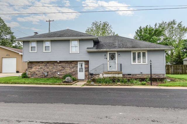 1502 S Mill St, Pontiac, IL 61764 - split level home with a detached garage, an outdoor structure, stone siding, a shingled roof, and driveway