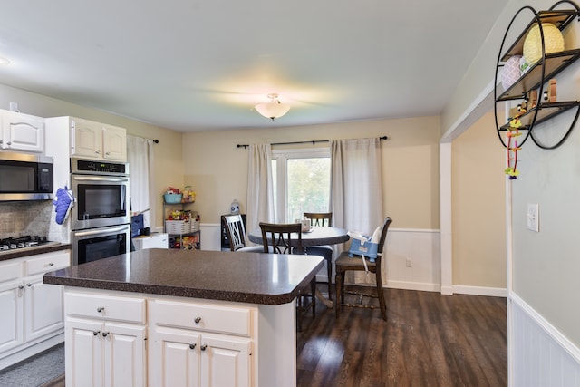 1502 S Mill St, Pontiac, IL 61764 - kitchen featuring stainless steel appliances, dark wood finished floors, dark countertops, white cabinets, and a kitchen island