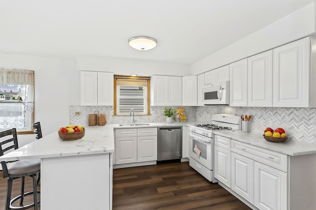 5923 W Giddings St, Chicago, IL 60630 - kitchen with white appliances, a sink, a peninsula, a kitchen bar, and dark wood-type flooring