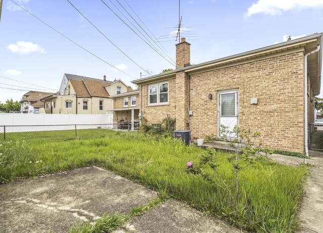 5923 W Giddings St, Chicago, IL 60630 - rear view of property featuring brick siding, a chimney, and central AC