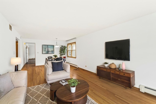 5923 W Giddings St, Chicago, IL 60630 - living room featuring a baseboard heating unit, wood finished floors, and baseboards