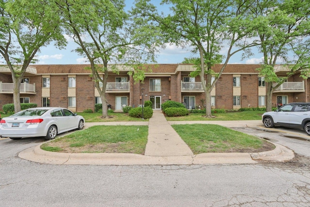 461 N Jonathan Dr Unit 104, Palatine, IL 60074 - view of front of property with uncovered parking, brick siding, and a front lawn