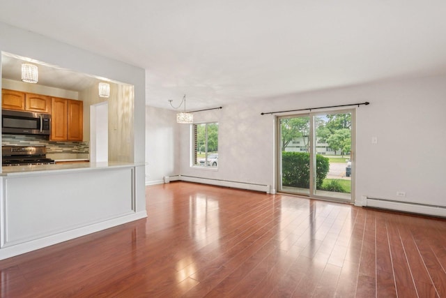 461 N Jonathan Dr Unit 104, Palatine, IL 60074 - unfurnished living room featuring baseboard heating, wood finished floors, and a chandelier