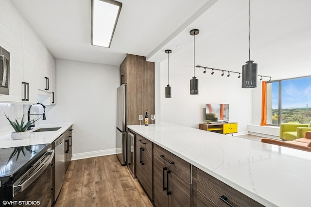 5455 N Sheridan Rd Unit 1606, Chicago, IL 60640 - kitchen with a sink, wood finished floors, stainless steel appliances, light stone counters, and baseboards
