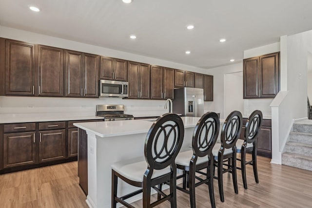 1486 Keller St, Elburn, IL 60119 - kitchen featuring stainless steel appliances, light wood finished floors, a kitchen island with sink, light countertops, and recessed lighting