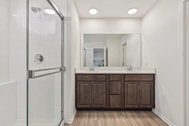 1486 Keller St, Elburn, IL 60119 - bathroom featuring baseboards, a stall shower, wood finished floors, and double vanity