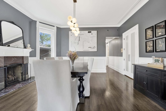 1814 N Lincoln Park W Unit 3, Chicago, IL 60614 - dining space with dark wood-style flooring, crown molding, a tiled fireplace, and a wainscoted wall