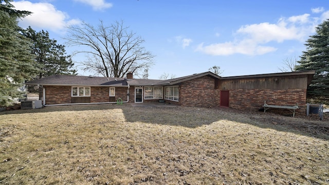 4012 Lisa Dr, Rockford, IL 61114 - rear view of house featuring brick siding, a chimney, and central air condition unit