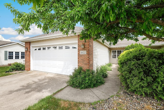 1622 Evergreen Ave, Crown Point, IN 46307 - view of side of property with brick siding, an attached garage, concrete driveway, and roof with shingles