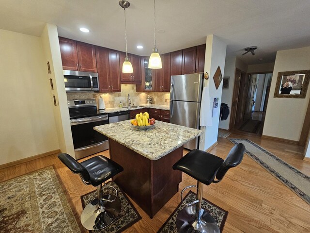 3110 Pheasant Creek Dr Unit 304, Northbrook, IL 60062 - kitchen with appliances with stainless steel finishes, a sink, baseboards, tasteful backsplash, and a center island