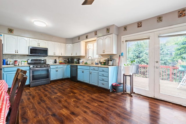 411 N Crestwood Ave, Mchenry, IL 60051 - kitchen featuring appliances with stainless steel finishes, blue cabinets, healthy amount of natural light, and decorative backsplash