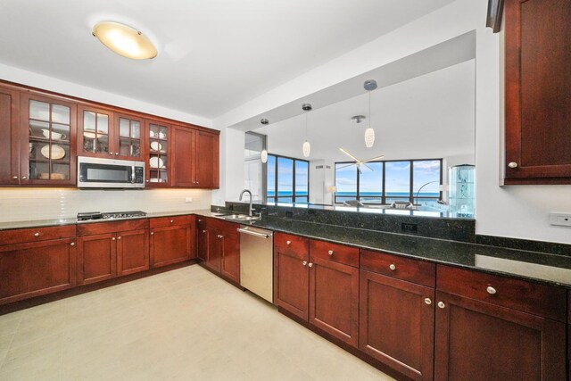 600 N Lake Shore Dr Unit 1105, Chicago, IL 60611 - kitchen with stainless steel appliances, a sink, dark stone countertops, decorative light fixtures, and reddish brown cabinets